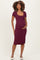 woman wearing a burgundy short sleeve maternity dress with a square neckline and holding her baby bump