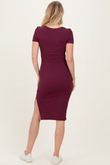 woman wearing a burgundy ribbed midi dress with short sleeves and a side slit, shown from the back
