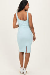 woman wearing a light blue maternity ribbed midi dress with a back slit and fitted silhouette