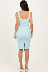 woman wearing a light blue ribbed midi dress with a back slit and wide straps