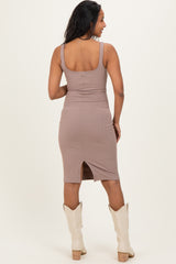 woman wearing a taupe ribbed maternity dress with a slit at the back and white cowboy boots
