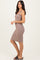 woman wearing a fitted taupe ribbed midi dress with spaghetti straps and black sandals