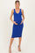 woman wearing a royal blue sleeveless maternity dress and cradling her baby bump