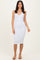 woman wearing a white ribbed midi dress with a v-neckline and slim fit, standing on a neutral background