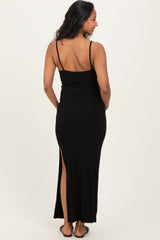 woman wearing a black maternity maxi dress with a side slit and adjustable spaghetti straps, showing her pregnant belly