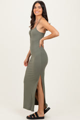 woman wearing a sage green ribbed maxi dress with a side slit and spaghetti straps