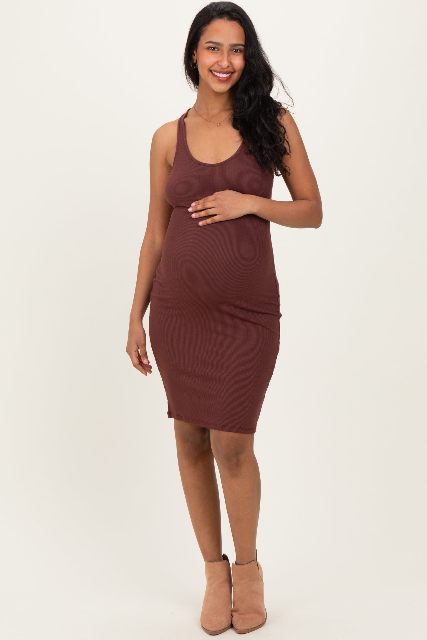 woman wearing a burgundy ribbed maternity dress and holding her baby bump