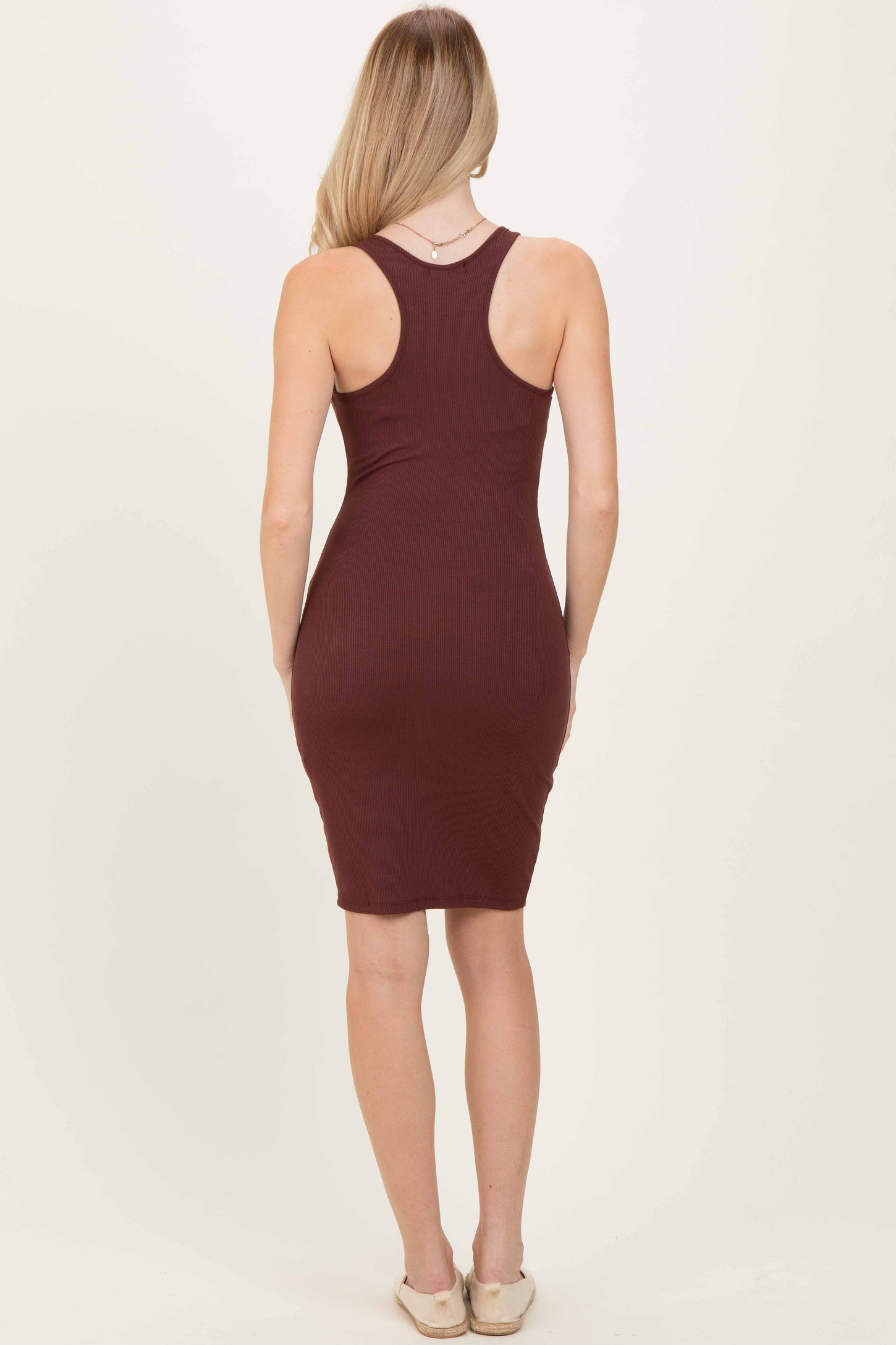 woman wearing a burgundy ribbed midi dress with a racerback style, shown from the back