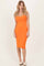 woman wearing an orange sleeveless bodycon midi dress, standing against a neutral background
