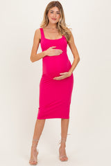 woman wearing a hot pink maternity dress, holding her baby bump with a fitted silhouette