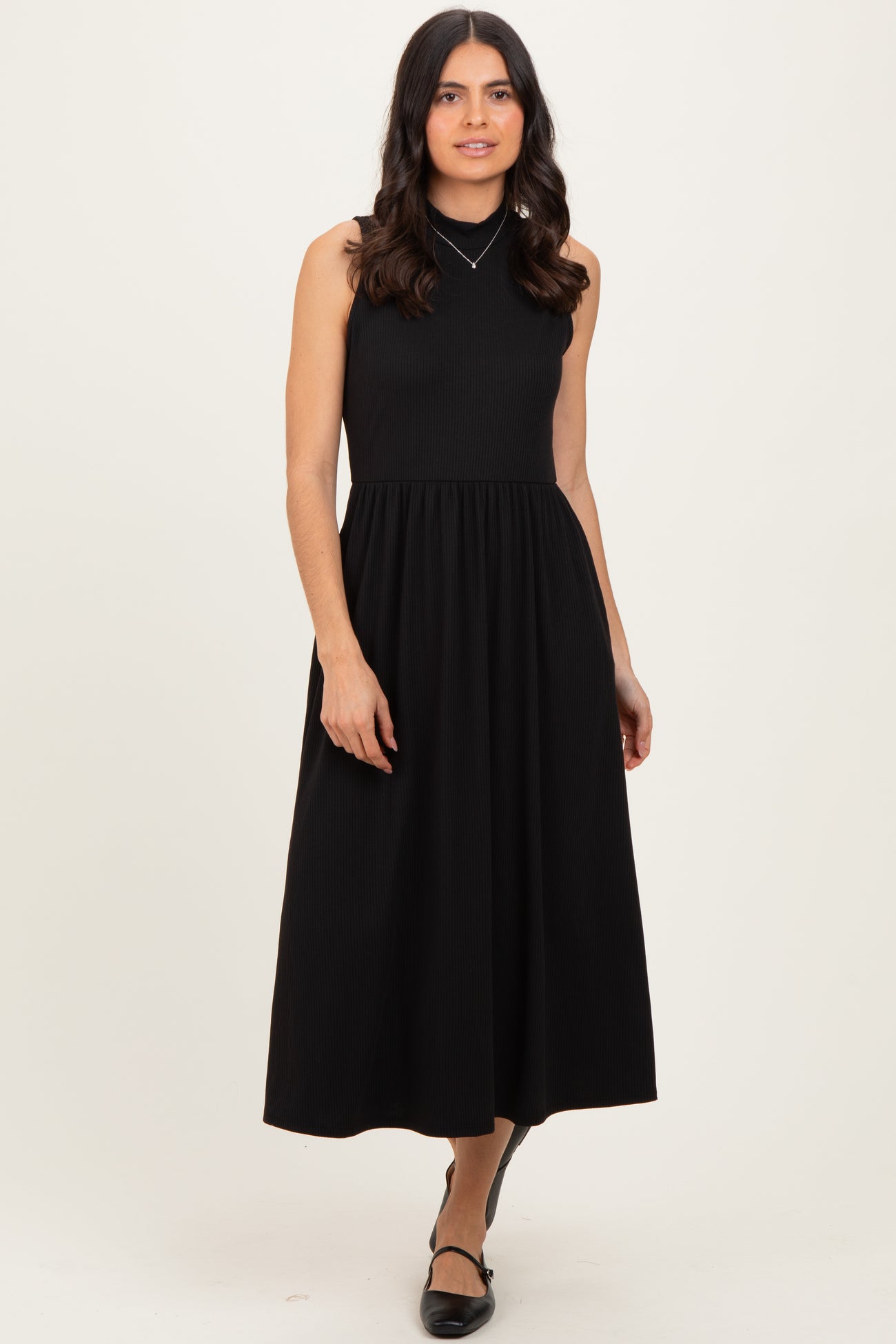 woman wearing a black sleeveless ribbed maxi dress with a fitted bodice and full skirt