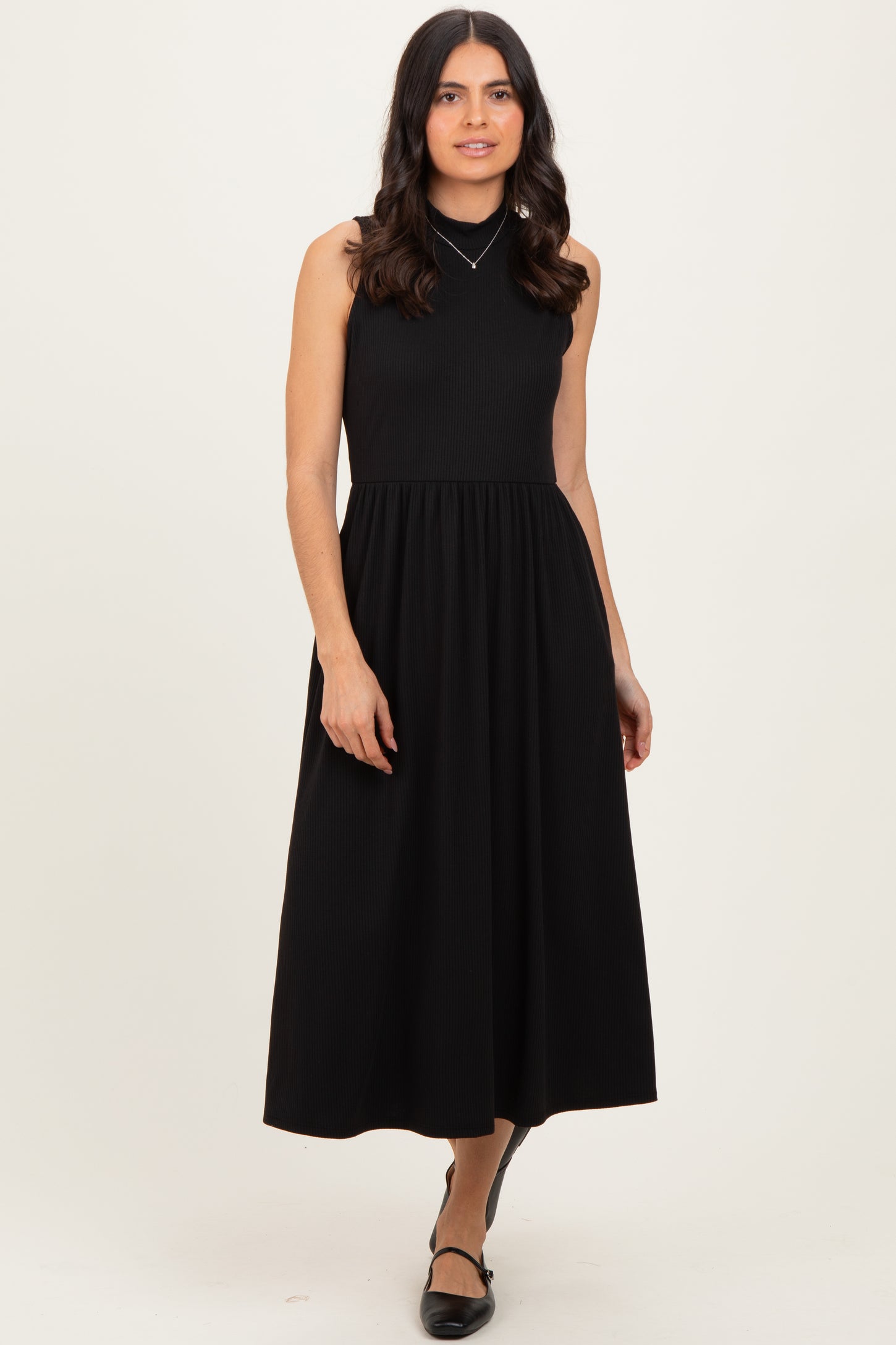 woman wearing a black sleeveless ribbed maxi dress with a fitted bodice and full skirt