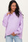 woman wearing a lavender maternity pullover with a buttoned collar and a baby bump visible