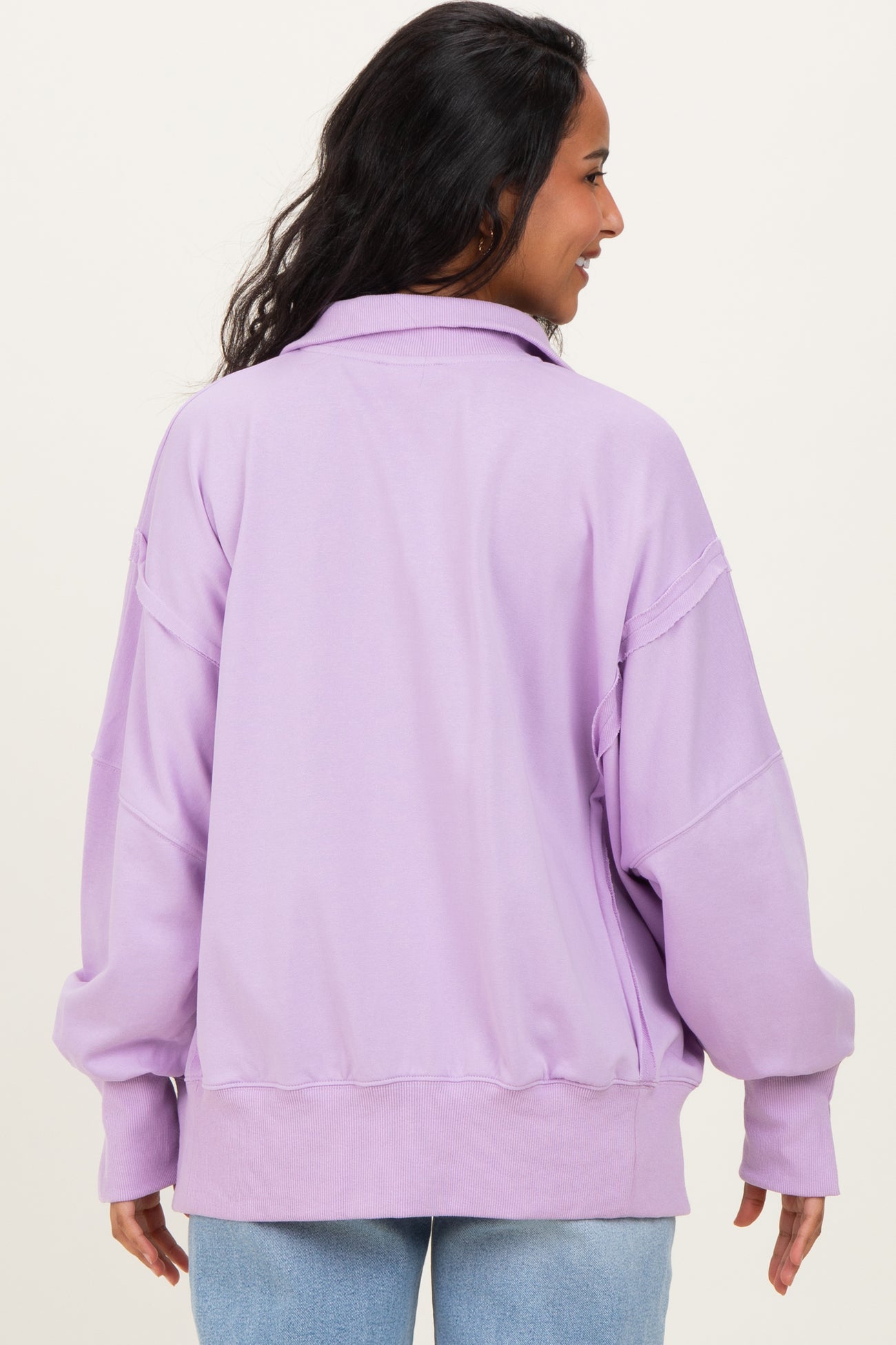 woman wearing a lilac oversized maternity sweatshirt with a relaxed fit and dropped shoulders, shown from the back