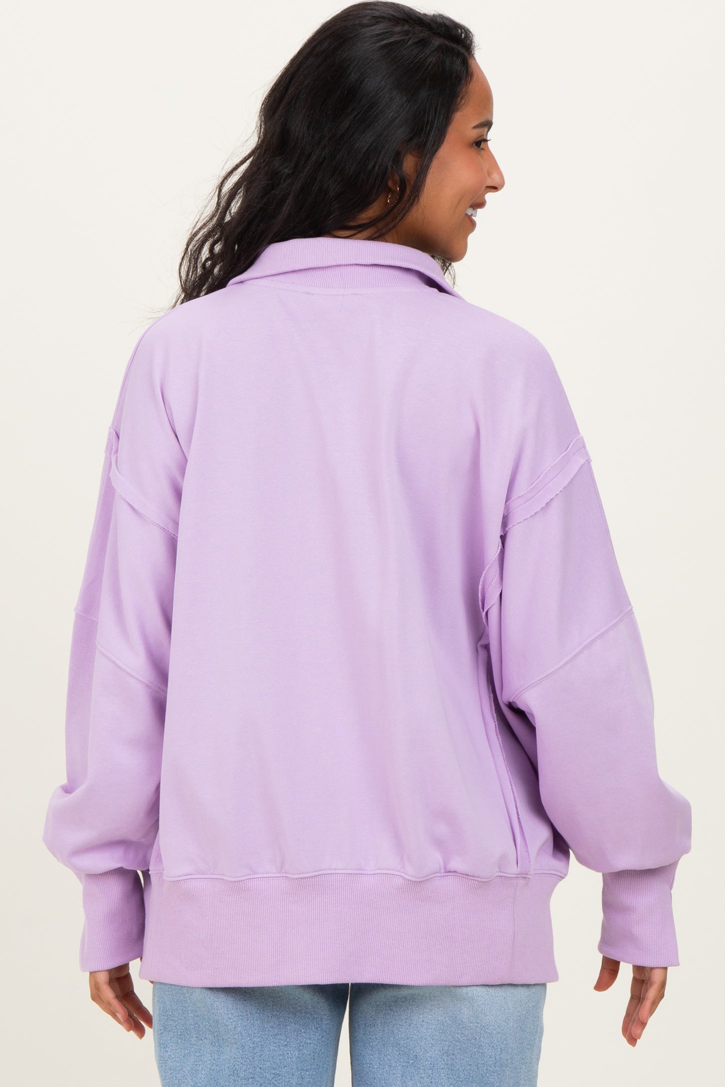 woman wearing a lilac oversized maternity sweatshirt with a relaxed fit and dropped shoulders, shown from the back