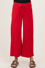woman wearing red wide-leg maternity pants with a drawstring waist and side pockets