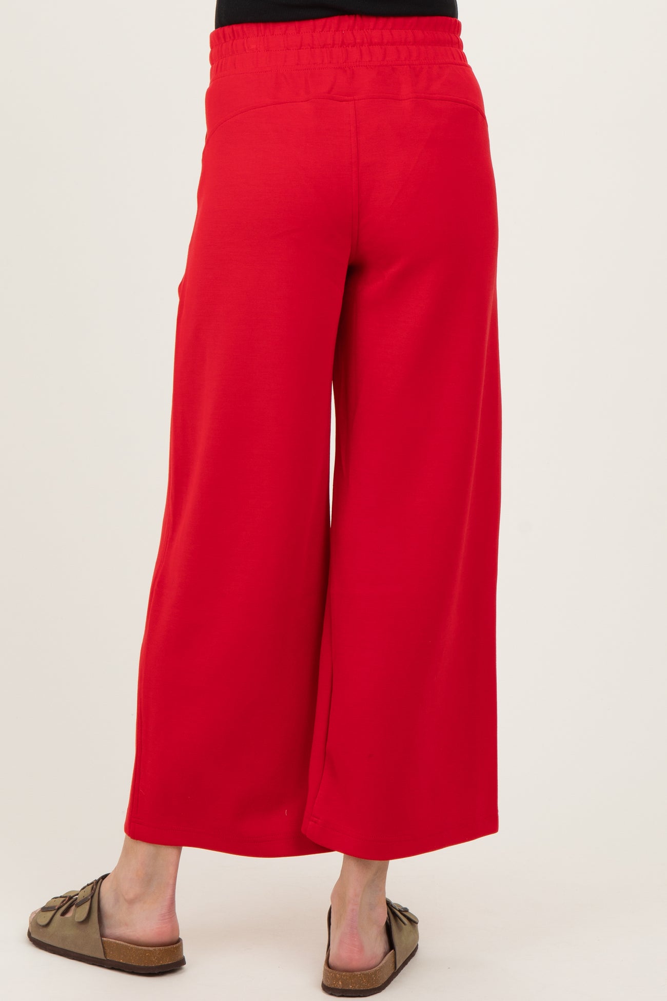 woman wearing red wide-leg maternity pants, seen from the back with an elastic waistband