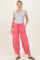 woman wearing gray short sleeve top and pink maternity pants with pockets, styled for comfort