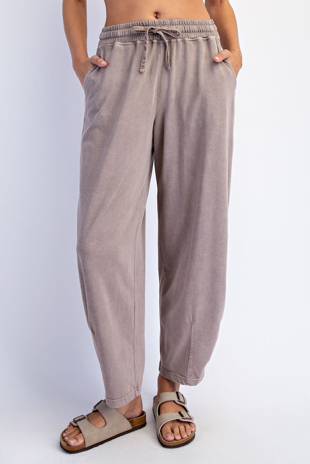 woman wearing light taupe relaxed-fit trousers with an elastic waistband and side pockets