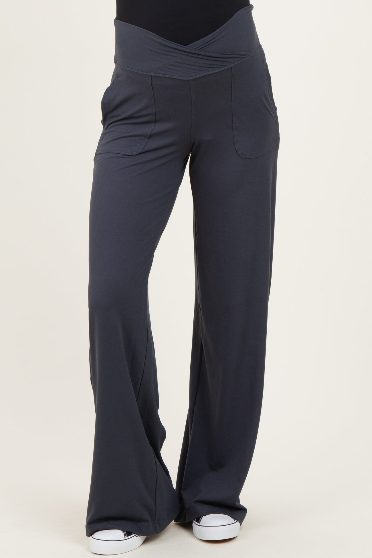 woman wearing dark gray maternity pants with a wide waistband and pockets