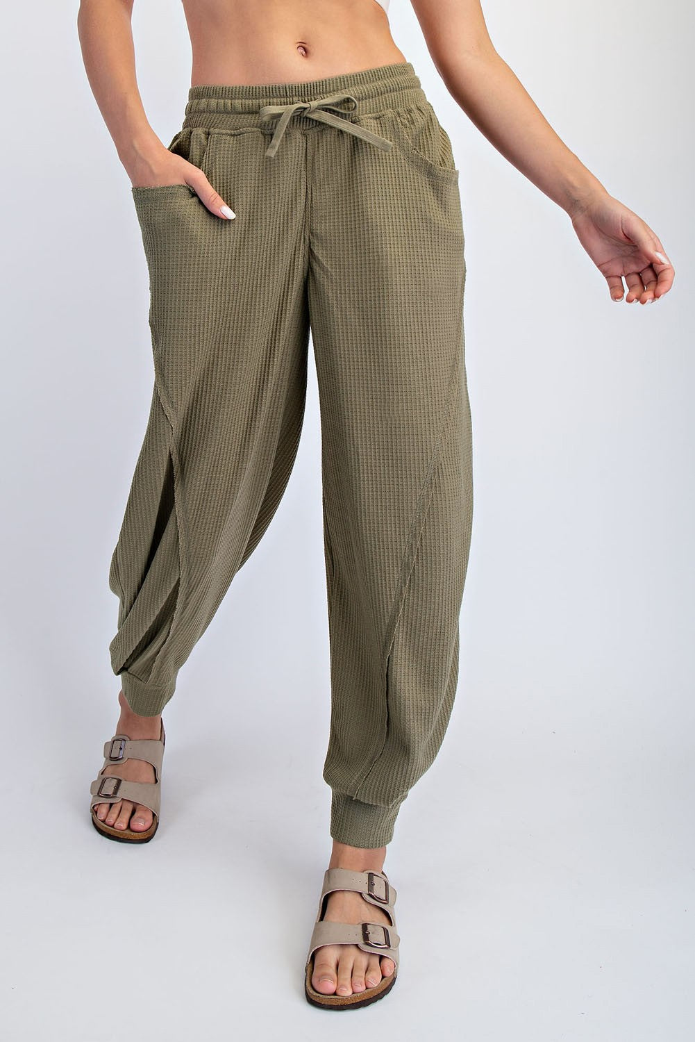 woman wearing olive green textured drawstring pants with side pockets and relaxed fit