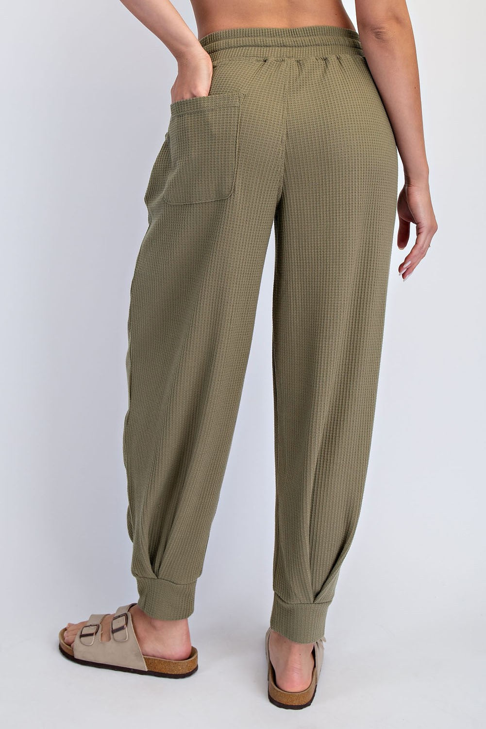 woman wearing olive green textured lounge pants with a relaxed fit and back pocket, standing sideways