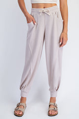 woman wearing light beige ribbed jogger pants with elastic cuffs and side pockets