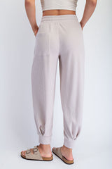 woman wearing light beige ribbed jogger pants with a tapered leg and back pocket, viewed from the back