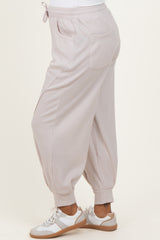 woman wearing light pink maternity jogger pants with a relaxed fit and side pockets