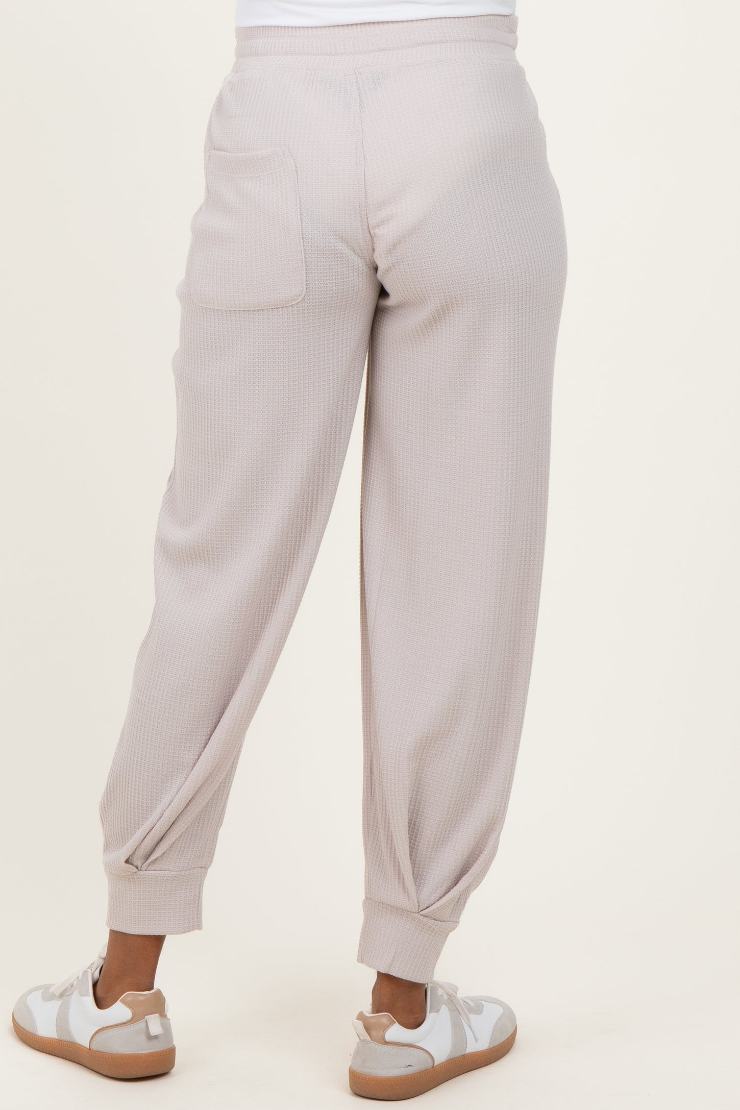 maternity wear light taupe ribbed joggers with elastic cuffs and back pocket, model shown from back