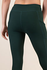 woman wearing dark green ribbed high-waisted leggings, focus on back view and seam detailing