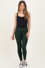 woman wearing a black maternity tank top and green ribbed maternity leggings