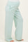 woman wearing light mint green maternity pants with side pockets and white piping, showcasing her baby bump