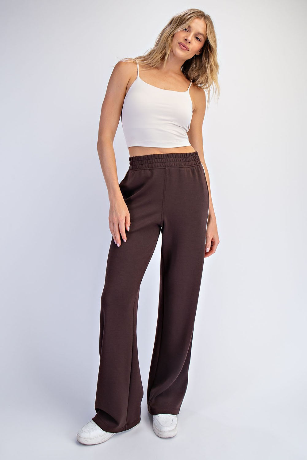 woman wearing a white cropped tank top and brown wide leg pants with an elastic waistband