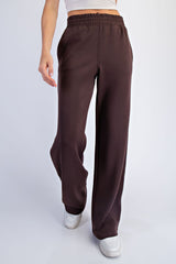 woman wearing brown wide-leg sweatpants with an elastic waistband and a relaxed fit