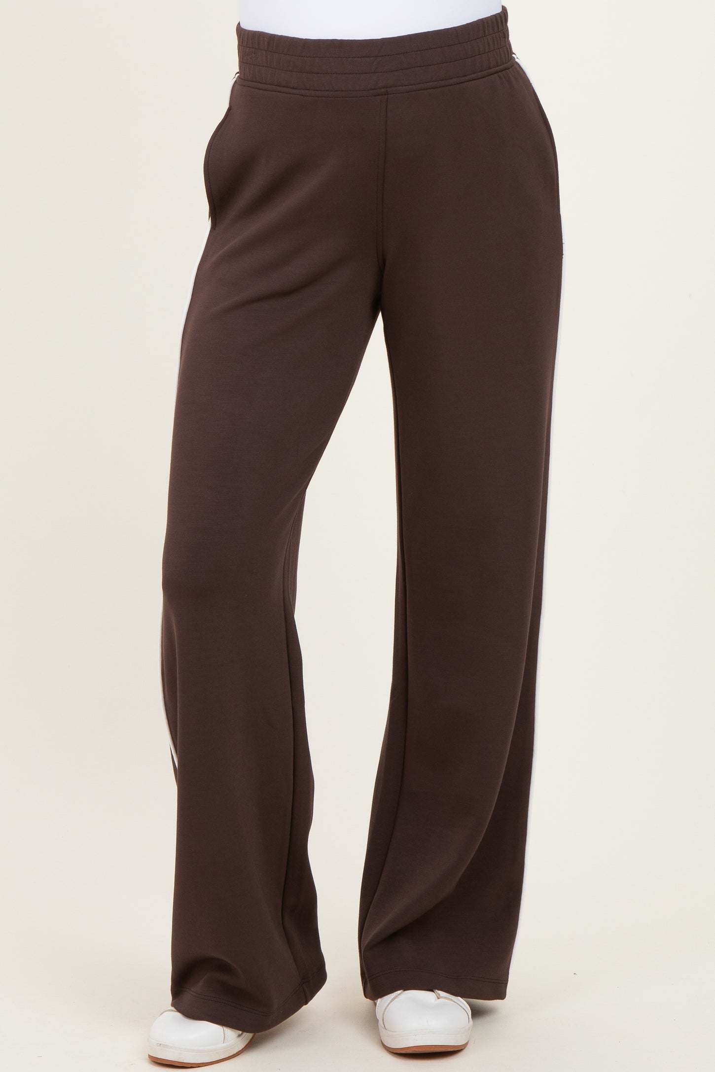 woman wearing brown maternity pants with a relaxed fit and elastic waistband