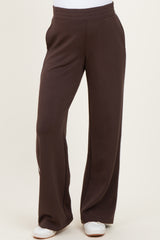 woman wearing brown maternity pants with a relaxed fit and elastic waistband