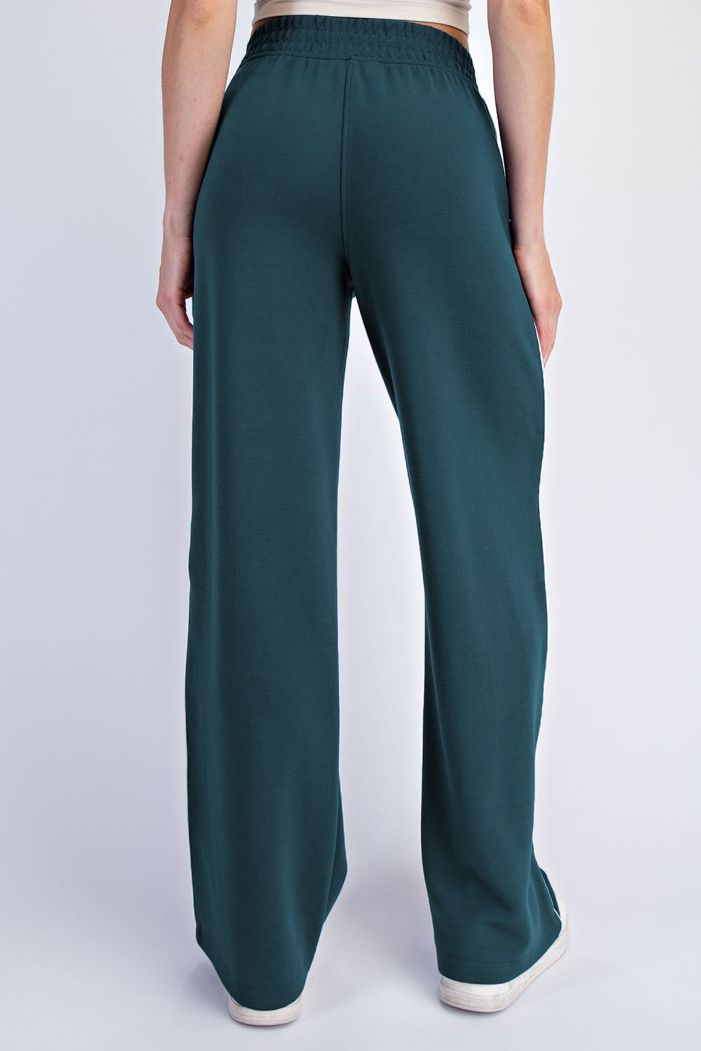 woman wearing teal wide-leg pants with a comfortable elastic waistband, shown from the back