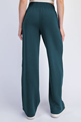 woman wearing teal wide-leg pants with a comfortable elastic waistband, shown from the back