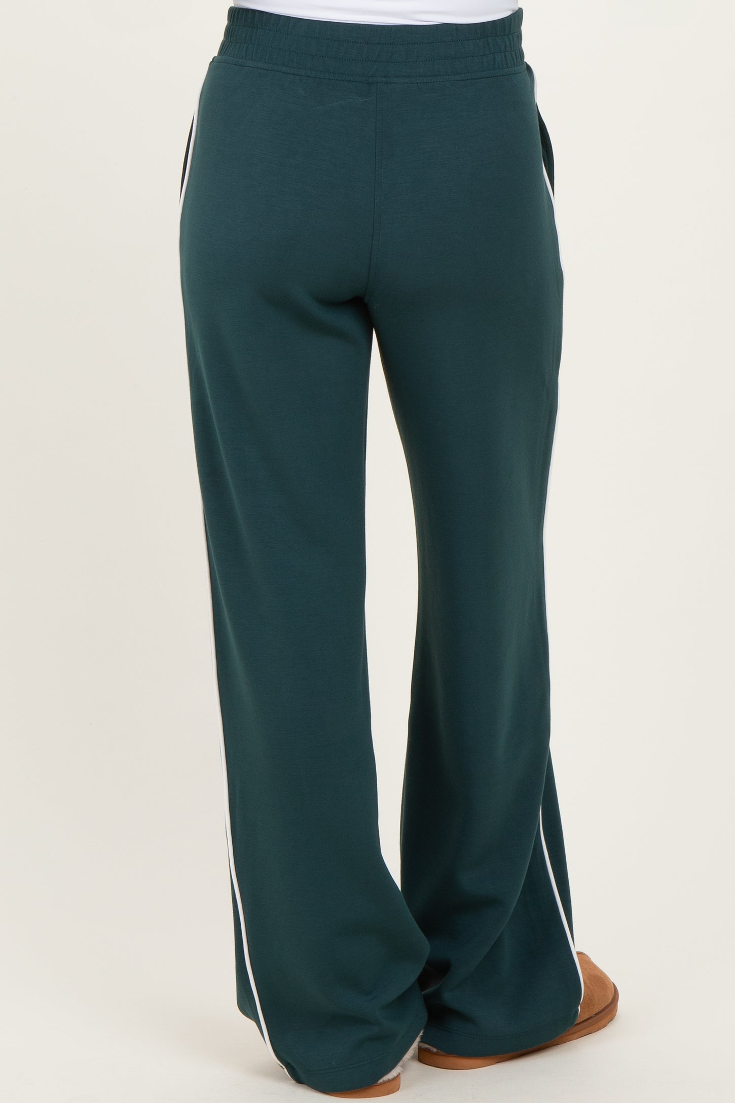 woman wearing green maternity sweatpants with side stripes, showing the back view