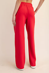 woman wearing red wide-leg pants with an elastic waistband, viewed from the back