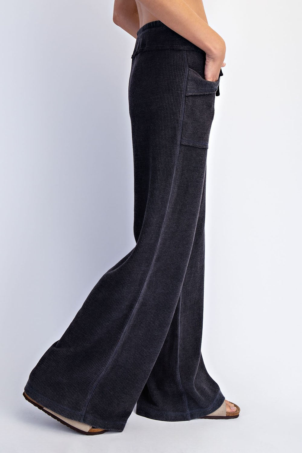 woman wearing black wide-leg corduroy pants with side pockets, shown from the side