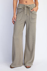 woman wearing olive green wide-leg ribbed pants with front pockets and a drawstring waist