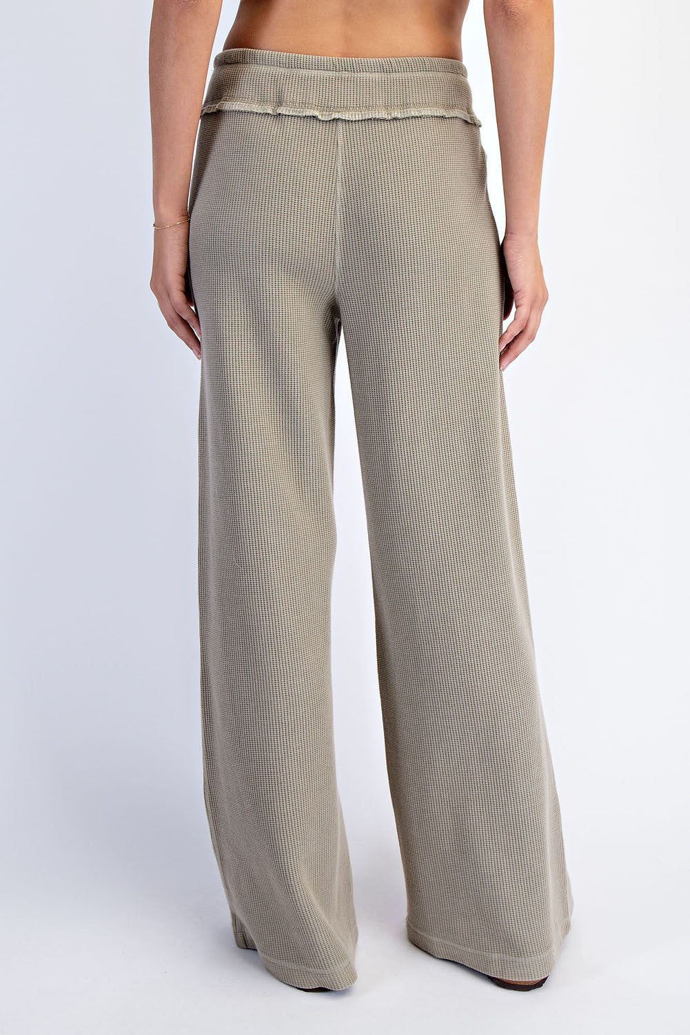 woman wearing beige wide leg ribbed pants, viewed from the back