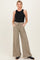 woman wearing a black sleeveless maternity top and beige wide leg pants with pockets