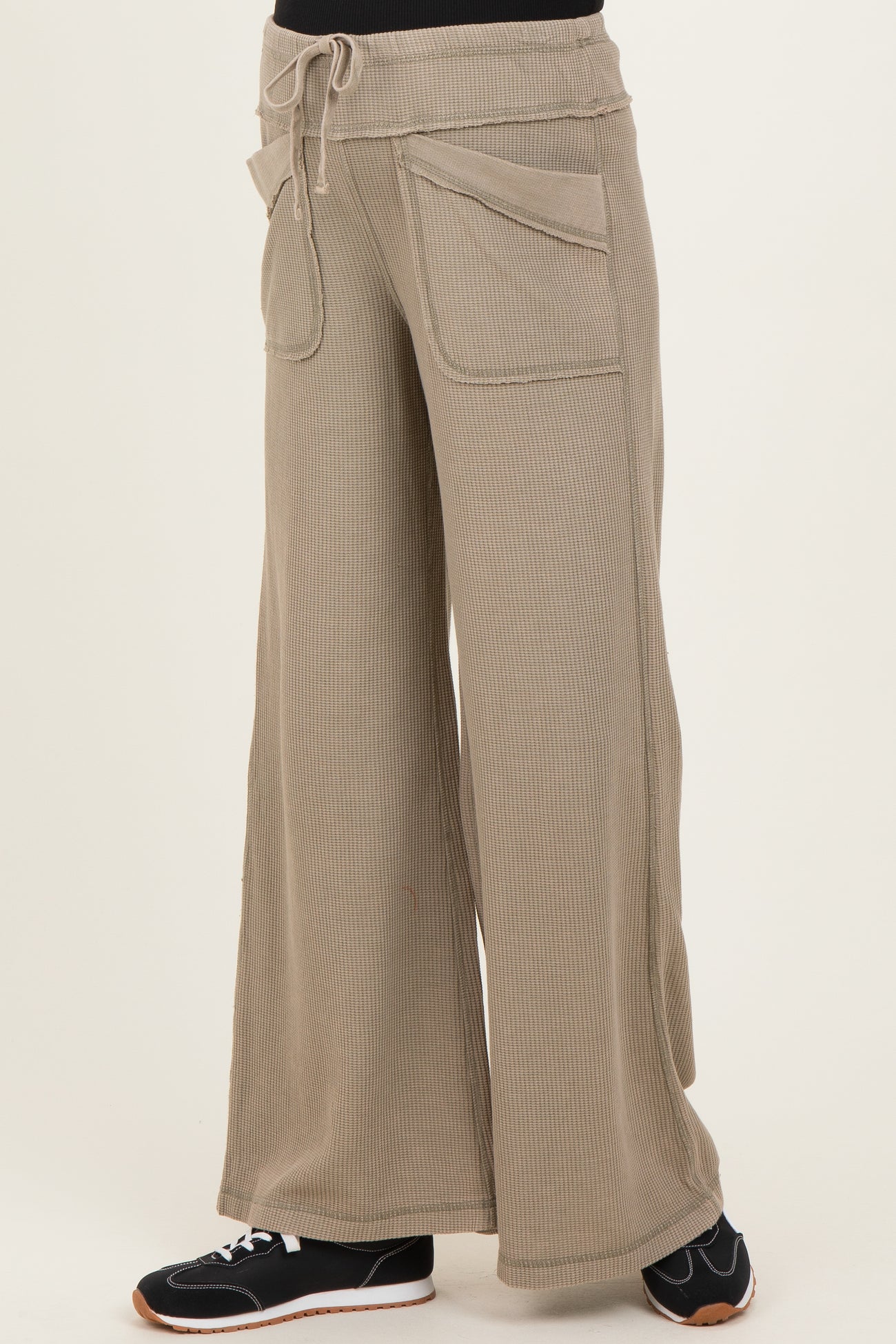 woman wearing beige wide-leg maternity lounge pants with pockets and an elastic waistband