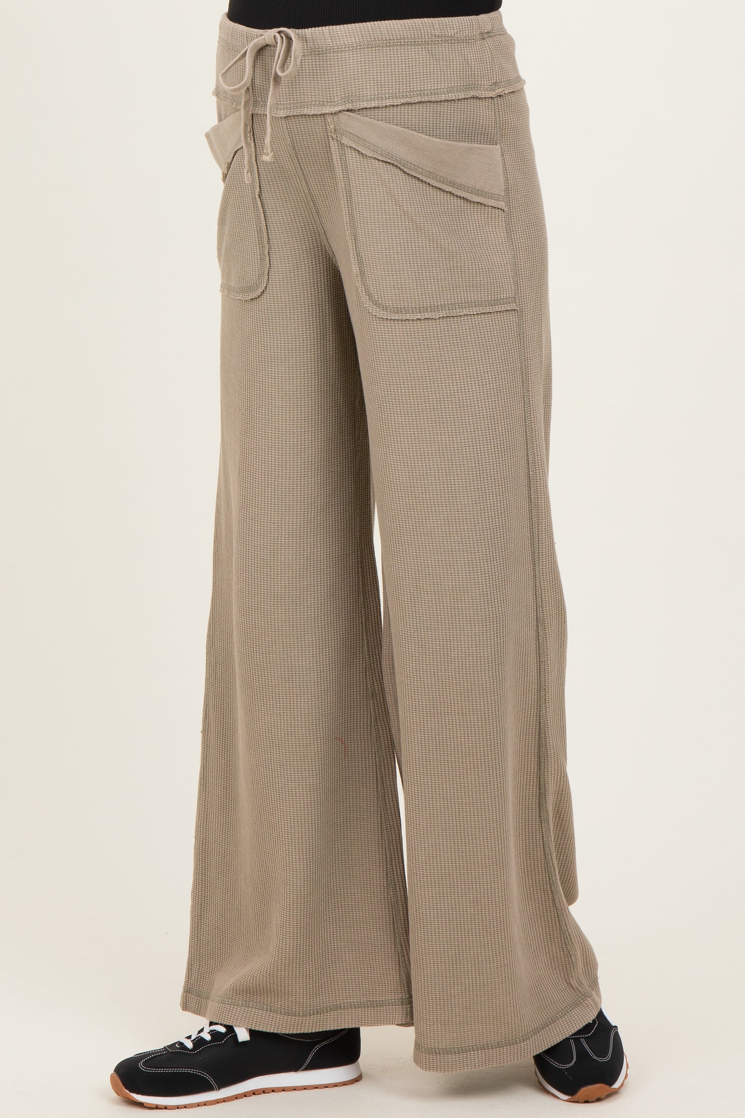 woman wearing beige wide-leg maternity lounge pants with pockets and an elastic waistband