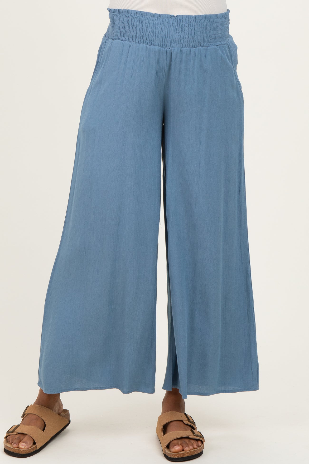 maternity wear in light blue wide-leg pants with smocked waistband, model wearing brown sandals