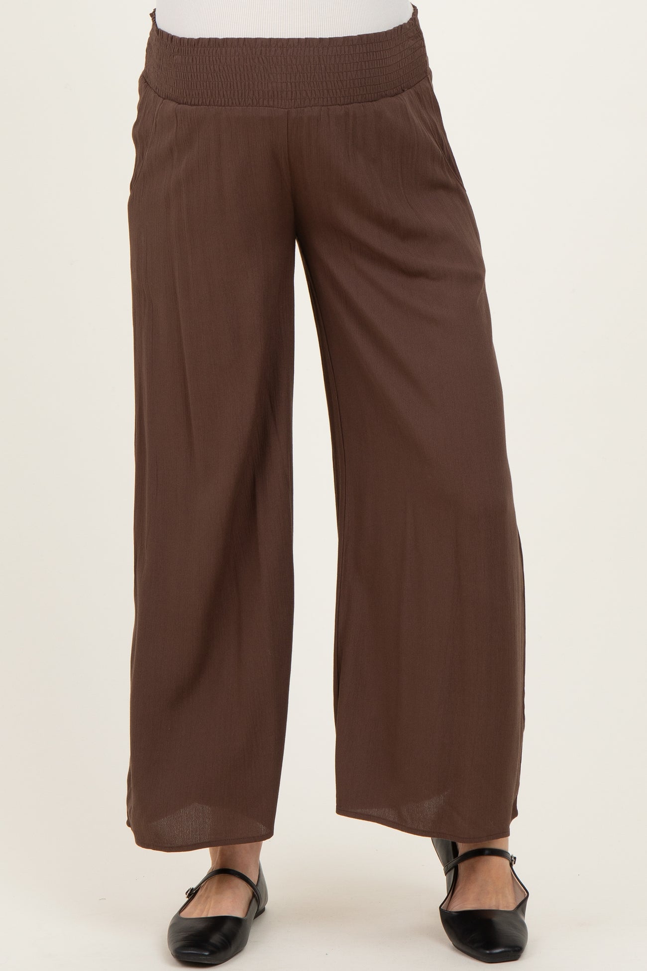 woman wearing brown maternity wide-leg pants with a smocked waistband