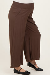 woman wearing brown maternity wide-leg pants with a smocked waistband and side pockets
